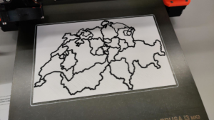 les contours d'une carte de la suisse sont imprimés en encre 3D noire