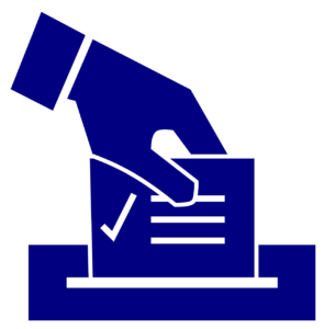 a hand places a ballot in a ballot box