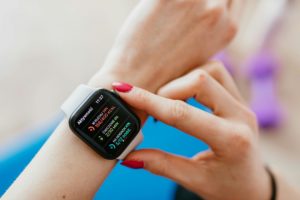 A smartwatch on a person&apos;s arm that displays sports data such as the number of steps taken.